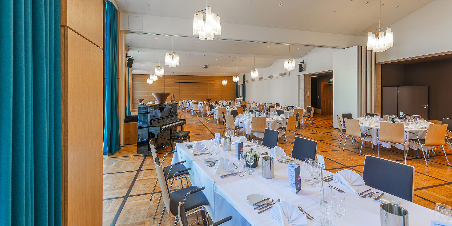 Elegant gedeckte Tische und farblich abgestimmte Dekoration im Festsaal